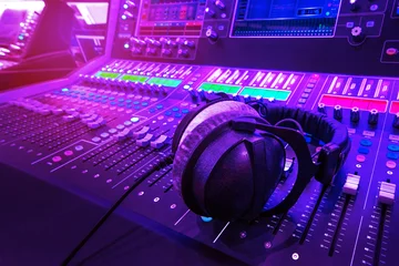 Tuinposter Professioneel audiostudio-geluidsmixerconsolebordpaneel met opname, faders en instelknoppen, tv-apparatuur. Blauwe en rode toon en close-up afbeelding met flare lichteffect. © zapp2photo