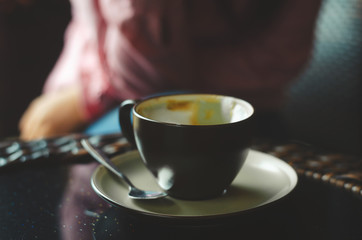close up modern hot black coffee the cappuccino on dark background with coffee bubble foam pattern and texture in black cup looking and feel so delicious on glasses table in coffee shop.