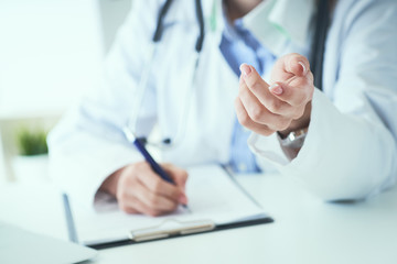Female doctor explaining patient symptoms or asking a question as they discuss together in a consultation. Doctor held out his hand to the patient close-up.