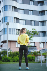 Sport woman in yellow is training in an urban environment.