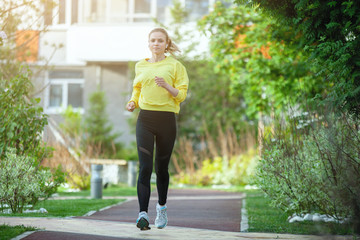 Sport woman in yellow is training in an urban environment.