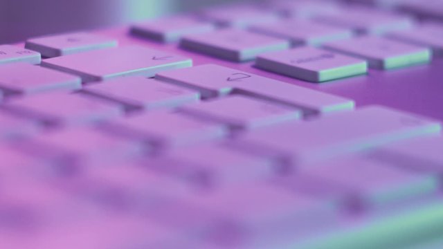 Macro Shot of Pressing Eneter Key on Keyboard in Pink Light