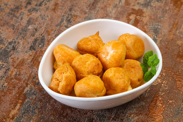 Sweet tasty profiteroles heap in the bowl