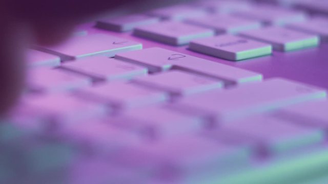 Macro Shot of Keyboard with Pressing Letter Keys and Enter. Sending Message or Typing Text in Pink Light