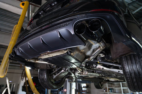 Bottom view of the car on a bifurcated exhaust system, rear bumper with a sports diffuser and nozzles in black. Tuning and atom service industry.