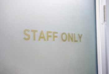 Staff Only Sign on a door with wall background