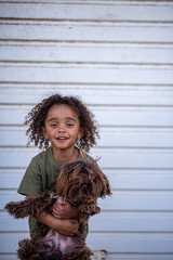 Adorable boy with curly hair holding his pet