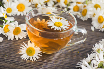 Glass cup with herbal tea with chamomile flowers