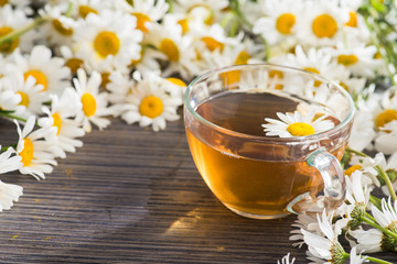 Glass cup with herbal tea with chamomile flowers