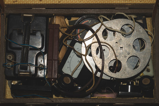 Case with various vintage things. old film reel. multimeters and wires