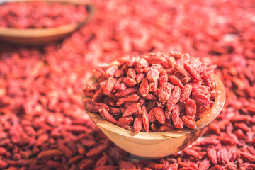 Wooden bowl with goji berries on the table closeup