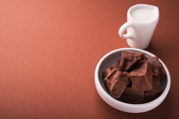 Pieces of chocolate and a carafe of milk