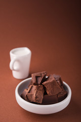 Pieces of chocolate and a carafe of milk
