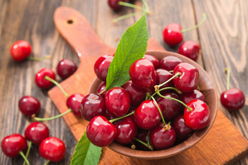 Fresh red cherries with slicing board on a wooden