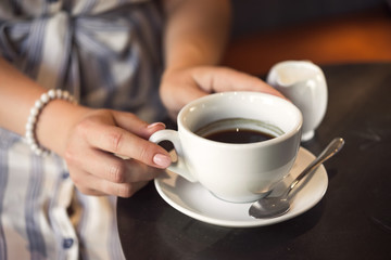 Young girl in a cafe with a coffee cup