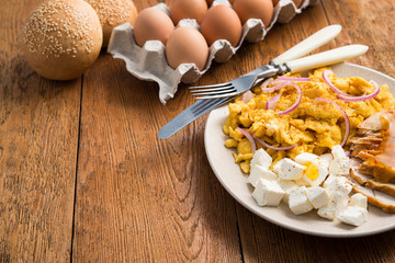 Rustic scrambled eggs, chicken fillet and feta cheese