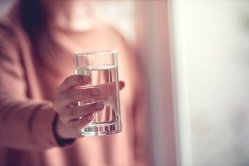 Young woman drinking water, copy space.