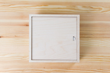 wooden plywood box lies on a wooden table. Copy space, close-up