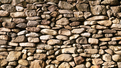 Pared de piedra volcánica con rocas redondas de color ocre