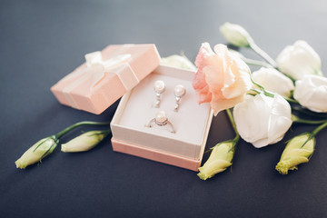 Set of pearl jewellery in gift box with flowers. Silver earrings and ring with pearls as a present for holiday.