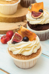 Cupcakes with Fig, persimmon and cream cheese on a wooden table