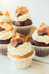 Cupcakes with Fig, persimmon and cream cheese on a wooden table