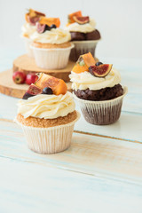 Cupcakes with Fig, persimmon and cream cheese on a wooden table