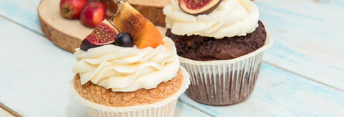 Cupcakes with Fig, persimmon and cream cheese on a wooden table