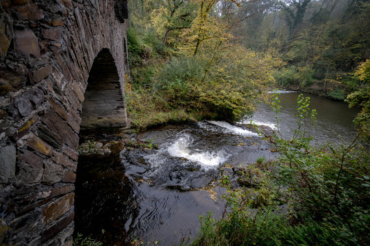 Fluss fließt durch eine Steinbrücke