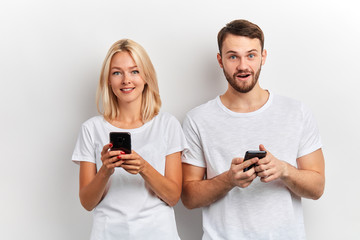 positive good looking couple surfing, browsing the net, doing shopping online, watching video, isolated white background. communication