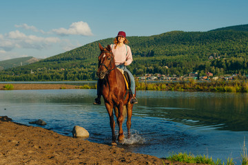 girl on a brown horse by the pond