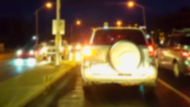 Turning Left at City Intersection at Night With Blur Effect.  Driver Point of View POV Waiting in Left Turn Lane With Urban Street Traffic.