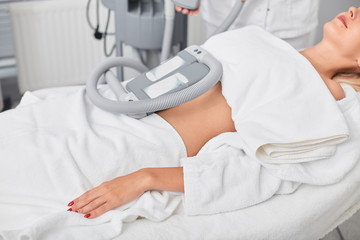 relaxed calm woman taking treatment in the clinic. close up cropped side view photo. machine for...