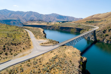 Obraz na płótnie Canvas Rural highway crosses a bridge over a reservoir in summer