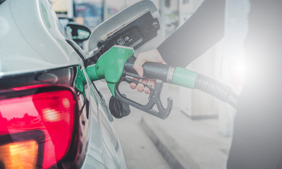 Woman pumping gasoline fuel in car at gas station. © Zedspider