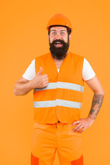 Master of quality. Master builder showing thumbs up on orange background. Bearded man master happy smiling in protective helmet and safety vest. Master of building