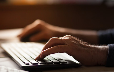 hands typing on computer keyboard