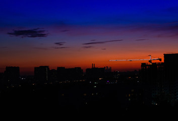  multi-storey buildings under construction and crane at night.