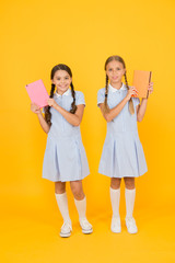Literacy club. Cute children holding books on yellow background. Little girls with encyclopedia or...