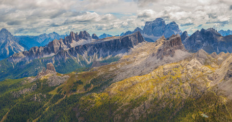 Fototapeta na wymiar Panoramic view of Cinque Torri on a cloudy day with opening peaks of the Julian Alps, Dolomites, Italy