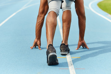 men's feet and arms on starting line, guy is ready for a sprint start.athlete preparing to run. close up cropped back view photo lifestyle, free time, hobby, interest