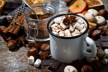 hot chocolate with marshmallows and sweets on wooden table