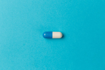 Pharmaceutical medicine pills, tablets and capsules on blue background. Top view. Flat lay. Copy...