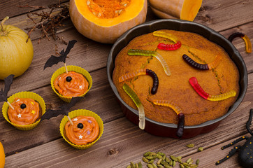 Pumpkin pie and cupcakes for Halloween with pumpkins, decorated with sweets