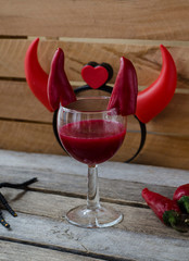 Red cocktail for Halloween celebration decorated with devil horns chili peppers