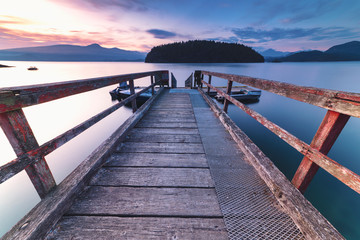 Brilliant sunset rocky beach scenes at sunset with mountains, sky and clouds lit up in early autumn.  Pacific North West Bowen Island British Columbia Canada close to Vancouver.