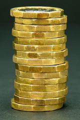 Stack of one British pound coins on a black background
