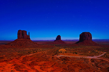 Obraz na płótnie Canvas View of Monument Valley at night with lots of stars in the sky in Navajo Nation Reservation in USA.