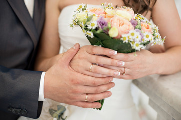 Obraz na płótnie Canvas The bride and groom's hands with rings