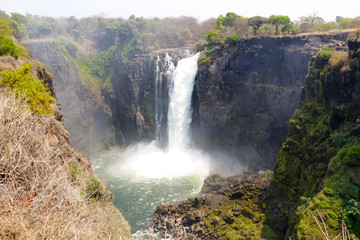The Victoria Falls are a wide waterfall of the Zambezi River between the border towns of Victoria...